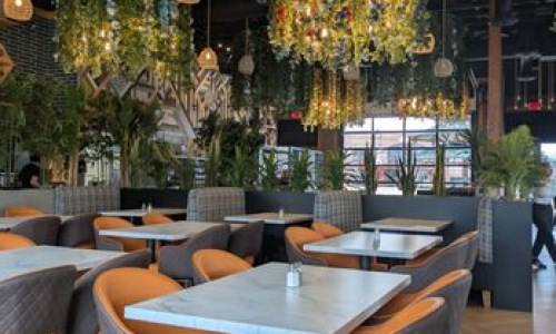 a restaurant with seating tables and plants