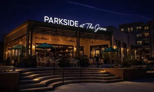 a building with a sign at night with umbrellas