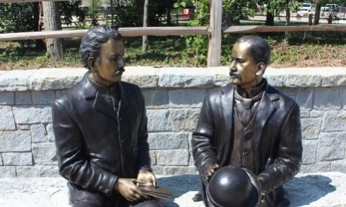 statues sitting on a bench