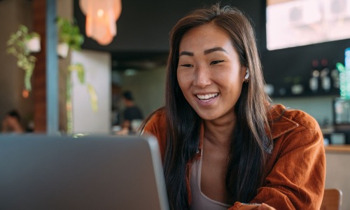 a woman smiling while working on laptop